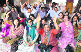 Teachers of the University of Jammu stage a protest in front of the Administrative Block in Jammu on Monday.