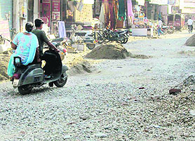 A scooterist making his way through dug up Railway Road Jagraon on Monday.