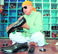 Pakistans Deputy Attorney General Muhammad Khurshid Khan polishes shoes during a visit to the Golden Temple in Amritsar on Tuesday.
