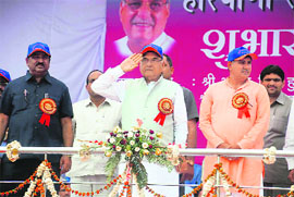 Chief Minister Bhupinder Singh Hooda takes the salute at a march past at the inauguration of the Haryana State Panchayat Sports Meet in Rai on Tuesday.