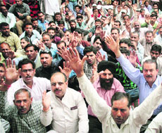 Members of PHE Workers Welfare Association stage a protest demanding a hike in the wages of casual workers at BC Road in Jammu on Tuesday.