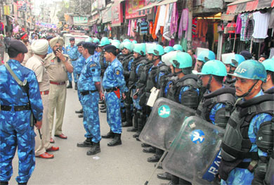 Police and paramilitary officers interact at Chaura Bazar in view of the bandh call for tomorrow, in Ludhiana on Tuesday. 
