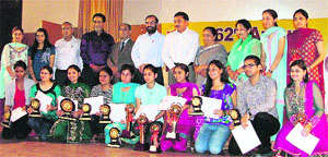 Students with trophies and certificates during the annual prize distribution function at Arya College, Ludhiana. 