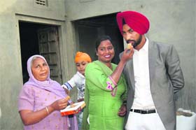 Rajinder Singh being offered a ladoo by a family member