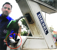 An employee of a petrol pump at Patel Chowk shows the seal on a fuel-vending machine affixed by MC officials in Jalandhar on Tuesday