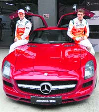 Sahara Force India drivers Nico Hlkenberg (L) and Paul di Resta with the Mercedes AMG car during an event at the Buddh International Circuit in Greater Noida on Tuesday