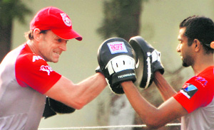 Adam Gilchrist (left), captain-cum-coach of Kings XI Punjab, boxes with the team physiotherapist at the PCA Stadium in Mohali on Wednesday.