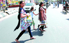 Women carry books and stationary items for their children before the beginning of the new academic session in Bathinda on Thursday.