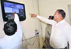 SP, Traffic Police, Dr Kiran Lal Shaw, inspects footage of a CCTV camera installed at the multiparking lot in Haridwar on Thursday