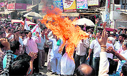 Members of the Swarankar Association burn an effigy of Union Finance Minister Pranab Mukherjee in Gurgaon on Thursday