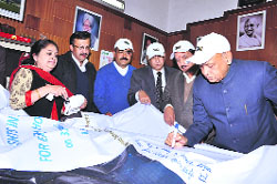 Chief Minister PK Dhumal launches a signature campaign from his official residence, Oakover, in support of Earth Hour in Shimla on Thursday.
