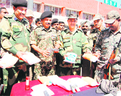 BSF officers show packets of heroin, a pistol and mobile phones seized from smugglers at Ramtirath near Amritsar
