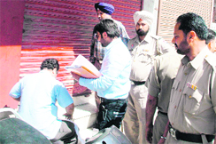 The MC house tax team seals ICICI Banks ATM booth at Hussanpura Chowk in Amritsar on Friday. 
