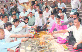 Members of a jewellers association perform a yajna in Haridwar on Friday; and (below) striking jewellers stage a demonstration in Dehradun. 