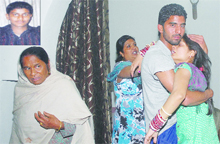 Family members of Vijay (inset) console each other at their residence in the Golden Street locality in Jalandhar.