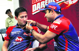 Delhi Daredevils captain Virender Sehwag pins a blue ribbon on Ajit Agarkars jersey during a Unicef event, at the Ferozshah Kotla Stadium, in New Delhi on Friday. 