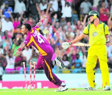 Australias Clint McKay (R) is bowled out by West Indies Dwayne Bravo (L) during the 2nd T20 in Bridgetown on Friday. 