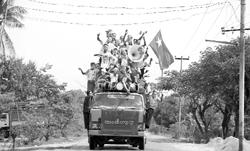 Aung San Suu Kyi supporters shout slogans atop a lorry during campaigning for the April 1 bypoll near Wah Thin Kha