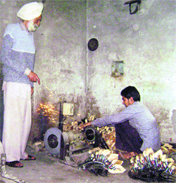 Surjit Singh, a sickle manufacturer, supervises work at his unit at Railway Road in Ahmedgarh.