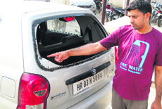 A man points to the bullet mark on a car at Dera Bassi on Monday. 