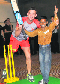 Adam Gilchrist raises hands of Gaurav of NGO Choti si asha during a friendly match on Monday.