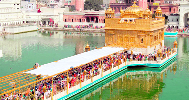 To provide a shelter to the pilgrims during the summer season, workers lay a retractable fabric sheet at the entrance to the Golden Temple on Monday.