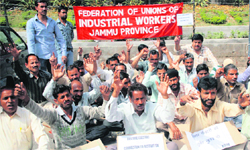 Members of the Federation of Unions of Industrial Workers stage a protest in Jammu 