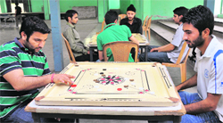 Players in action during a carrom final in the Inter-Department Competitions at Gymnasium Hall, University of Jammu