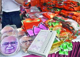 Masks of BJP senior leader LK Advani and posters of the party on sale in New Delhi on Wednesday