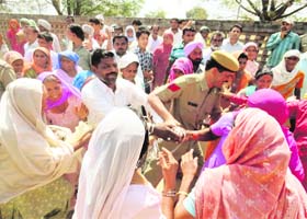 Women snatch measuring tape and other equipment from Town Planning officials in Ratia on Wednesday