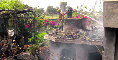 Firemen douse the flames after a fire broke out in a motor vehicle company in Jammu on Wednesday. 