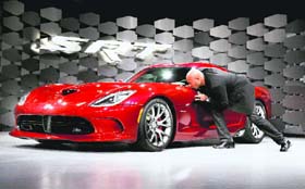 Ralph V. Gilles, president and CEO of Chrysler's SRT Brand, kisses the SRT Viper as it's unveiled at the New York International Auto Show, in New York on Wednesday