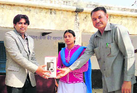 Sunil Jaglan, sarpanch of Bibipur, awards students for their role in an energy conservation drive in the village at a function held there recently. 