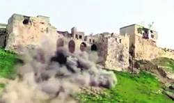 An image grab shows smoke billowing from reported shelling on the archaeological Greco-Roman ruins of the Citadel of al-Madiq in Apamea in northeastern Syria.