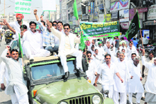 INLD workers led by Gharounda MLA Narender Sangwan (sitting on jeep wearing goggles) raise anti-government slogans in Karnal on Friday. 