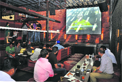 Youngsters enjoy an IPL match on a big screen at a pub in Gurgaon. 