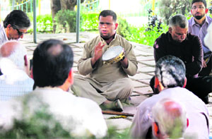 Rinku Verma, who is visually handicapped by birth, sings a Dogri song to an attentive audience at Mansar Lake in Samba district. 