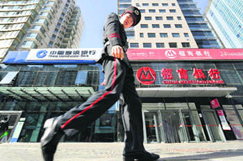 China prepares to break big-bank monopoly: A security worker walks in front of offices of various banks along a street in Beijing. China's Premier Wen Jiabao has called for the breakup of a banking "monopoly" on lending that has squeezed private businesses as the global economy slows down, Chinese state media reported.