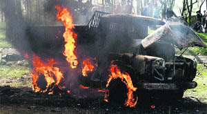A tipper goes up in flames after an angry mob set it on fire following the death of a cyclist in a road accident at Bagh-i-Mehtab on the outskirts of Srinagar on Saturday. 