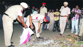 Police officials collect bones of a human skeleton in Jalandhar on Friday.