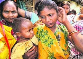 Tribal woman Hirmani Gauda with her one-year-old son Ganesh at Bandhaguda village in Malkangiri district of Odisha on Saturday