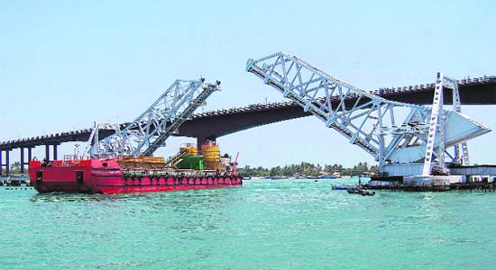 The railway bridge across the Pamban Sea opens up to allow a ship to pass under it, in Rameshwaram on Saturday