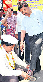 A member of the Jewellers Welfare Association polishes shoes in protest against the excise duty and consumer tax imposed by the Centre in Patiala on Saturday