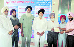 Gurdeep Singh Sahota being honoured for his services for minority communities by the Gursikh Education Society at a function in Dehradun on Sunday
