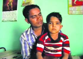 A file photo of Nitesh (5) with his father, Pawan, at their house in Julana