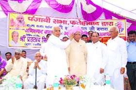 Leaders of the Punjabi community offer a turban as a mark of respect to Rajya Sabha MP Shadi Lal Batra at Fatehabad on Sunday