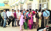 People queue up outside the SDMs office for the issuance of high security registration plates.