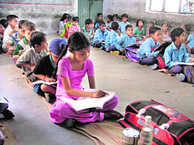 Students of a government school sit on the ground as it lacks basic infrastructure in Salem Tabri