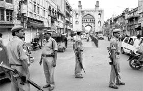 Armed policemen guard a street near Charminar after shops were closed on request by the police following clashes between two groups in Hyderabad on Sunday.