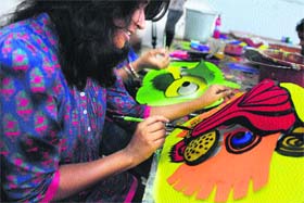 An arts student paints masks for the Bengali New Year day, that falls on April 14, in Dhaka on Sunday